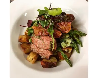 a white plate of food with meat and vegetables at Seabreeze Restaurant With Rooms in Aberdyfi