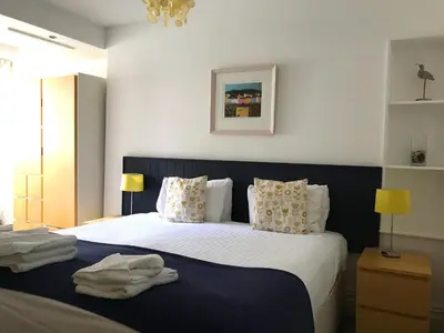 a bedroom with a bed with white sheets and pillows at Seabreeze Restaurant With Rooms in Aberdyfi