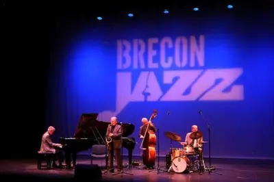a group of men on a stage playing music at Riverside in Brecon