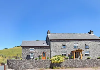 an old stone house with a stone wall at 1 Bed in Nantygwreiddyn oc-bow49 in Sennybridge