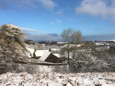 a house covered in snow in a field at The House In The Hills in Velindre