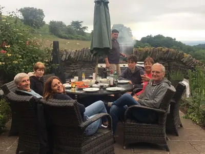 a group of people sitting around a table on a patio at The House In The Hills in Velindre