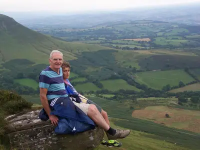 a man and a boy sitting on top of a rock at The House In The Hills in Velindre