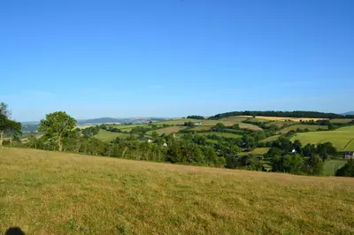 a grassy hill with a view of the countryside at Little Drift in Edgton