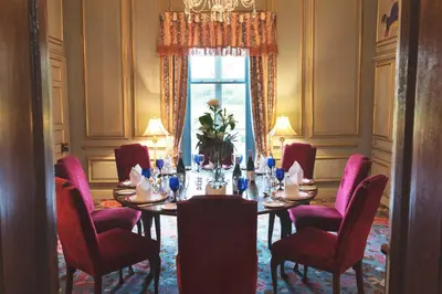 a dining room with a table and red chairs at Rowton Castle in Shrewsbury