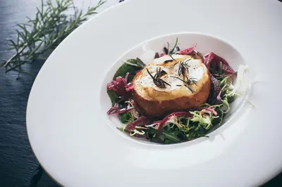 a bowl of food with a piece of meat on a salad at Rowton Castle in Shrewsbury