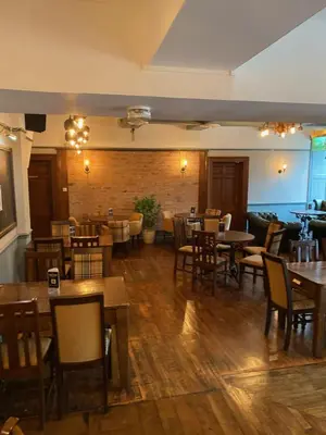 a restaurant with tables and chairs in a room at The Hand Hotel Llangollen by Compass Hospitality in Llangollen