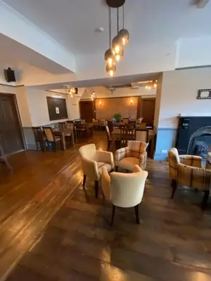 a lobby with couches and chairs and a restaurant at The Hand Hotel Llangollen by Compass Hospitality in Llangollen