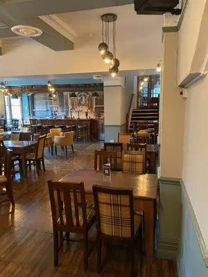 a dining room with wooden tables and chairs at The Hand Hotel Llangollen by Compass Hospitality in Llangollen