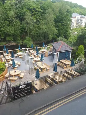 a group of tables and chairs with blue umbrellas at The Hand Hotel Llangollen by Compass Hospitality in Llangollen