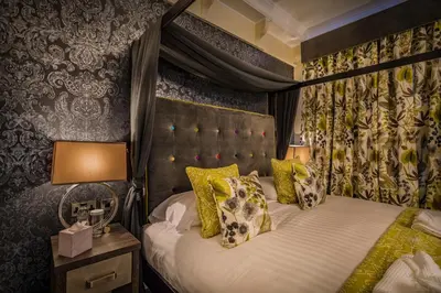 a hotel room with a bed with a canopy gmaxwell gmaxwell gmaxwell at The Royal Oak Hotel, Welshpool - The Coaching Inn Group in Welshpool
