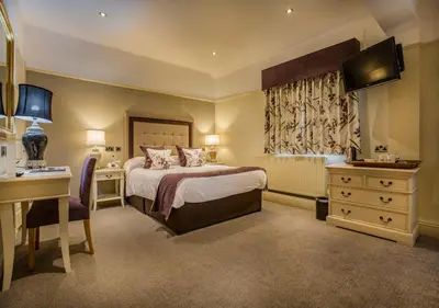 a hotel room with a bed and a desk and a desk at The Royal Oak Hotel, Welshpool - The Coaching Inn Group in Welshpool