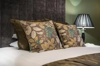a bed with two pillows on it with a lamp at The Royal Oak Hotel, Welshpool - The Coaching Inn Group in Welshpool