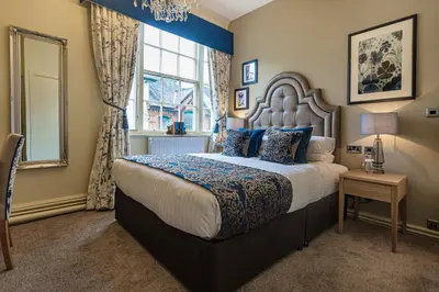 a bedroom with a large bed and a window at The Royal Oak Hotel, Welshpool - The Coaching Inn Group in Welshpool