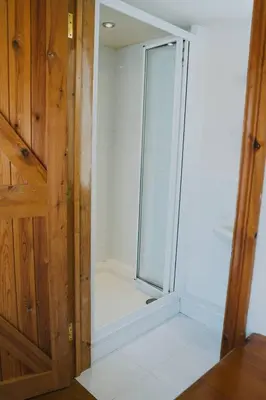 a bathroom with a shower with a glass door at Henllys Estate B and B in Llandovery