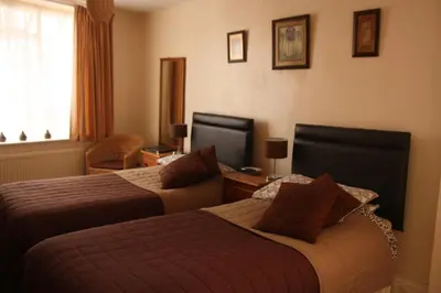 a hotel room with two beds and a television at The Horseshoe Guesthouse in Rhayader