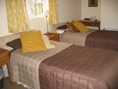 a hotel room with two beds with yellow pillows at The Horseshoe Guesthouse in Rhayader