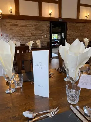 a table with white napkins and glasses on it at Black Mountain Lodge in Glasbury