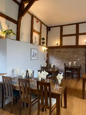 a dining room with a wooden table and chairs at Black Mountain Lodge in Glasbury