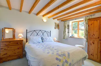 a bedroom with a bed and a dresser and a window at 2 Bed in Machynlleth oc-wad305 in Cemmaes