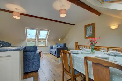 a kitchen and living room with a table and chairs at 2 Bed in Machynlleth oc-wad305 in Cemmaes