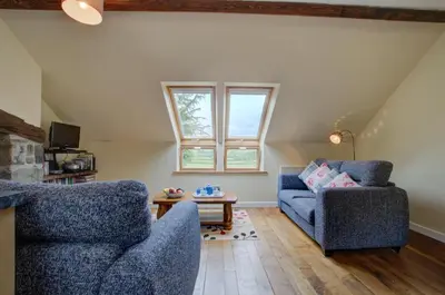 a living room with two blue chairs and a table at 2 Bed in Machynlleth oc-wad305 in Cemmaes