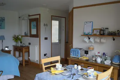 a room with a table and a bed and a kitchen at Smithfield Farm Bed & Breakfast in Builth Wells