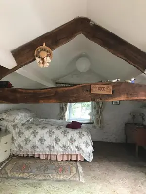 a bedroom with a bed with a wooden frame at Pen y Crug Cottage in Llanafan-fawr