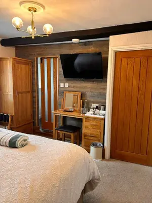 a bedroom with a bed and a desk with a television at Henwick house accommodation, Continental breakfast included in Ludlow