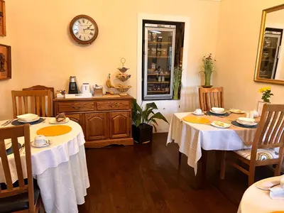 a dining room with two tables and a clock on the wall at Henwick house accommodation, Continental breakfast included in Ludlow