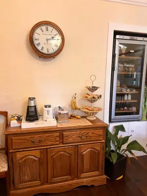a clock on the wall above a wooden dresser at Henwick house accommodation, Continental breakfast included in Ludlow