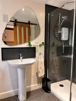 a bathroom with a sink and a shower with a mirror at Henwick house accommodation, Continental breakfast included in Ludlow
