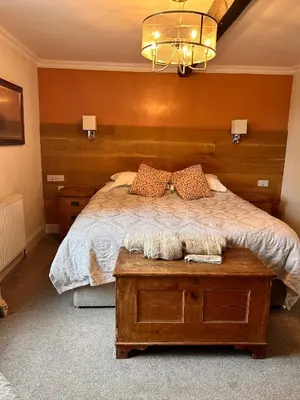 a bedroom with a large bed with a wooden headboard at Henwick house accommodation, Continental breakfast included in Ludlow