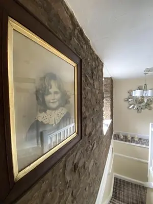a framed picture of a girl on a wall at Rooms at The Usk in Talybont