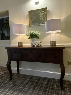 two lamps on a wooden table with flowers on it at Rooms at The Usk in Talybont