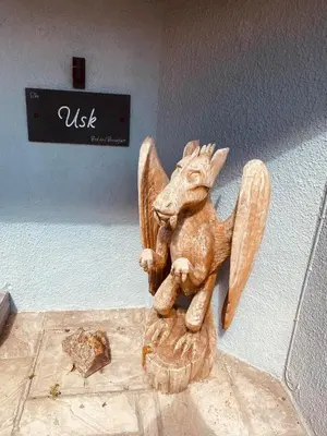 a small wooden angel statue sitting on a wall at Rooms at The Usk in Talybont
