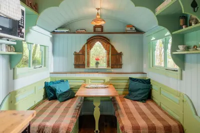 a small room with a table and two benches at Llethrau Forest & Nature Retreats in Knighton