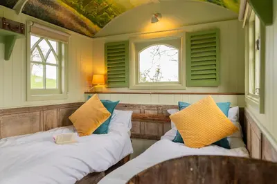 two beds in a room with two windows at Llethrau Forest & Nature Retreats in Knighton