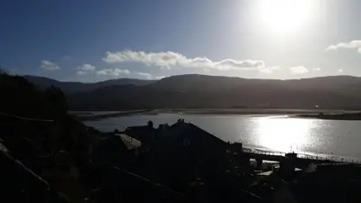 a view of a lake with the sun shining on it at Penbryn Holidays, Barmouth in Barmouth