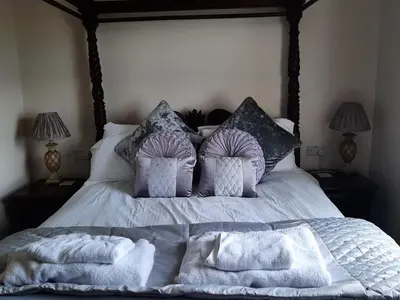 a bed with white sheets and pillows on it at Cadwgan House in Dyffryn