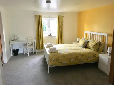 a bedroom with a bed and a desk and a window at Winforton B&B in Winforton
