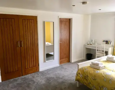 a bedroom with a bed and two wooden doors at Winforton B&B in Winforton