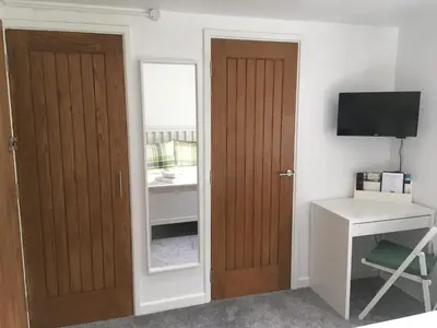 a room with a door and a desk and a television at Winforton B&B in Winforton