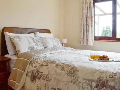 a bedroom with a bed with a tray of food on it at Three Views Bungalow in Talgarth