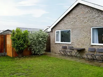 a patio with chairs and a table in front of a house at Lle Clyd in Harlech