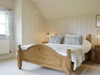 a bedroom with a wooden bed with blue and white pillows at Green Lane Cottage in Newtown