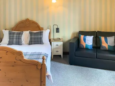 a bedroom with a bed and a couch at Green Lane Cottage in Newtown