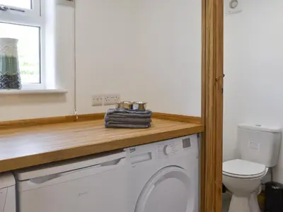 a washing machine in a bathroom with a toilet at Bryn Salem in Mallwyd
