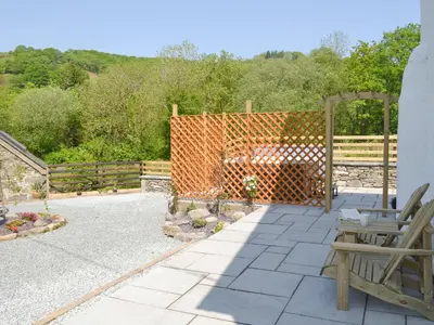 a patio with a fence and a table and chairs at Bryn Salem in Mallwyd