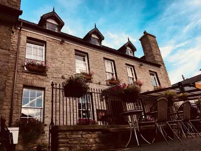 a brick building with windows and chairs in front of it at The Kilverts Inn in Hay-on-Wye